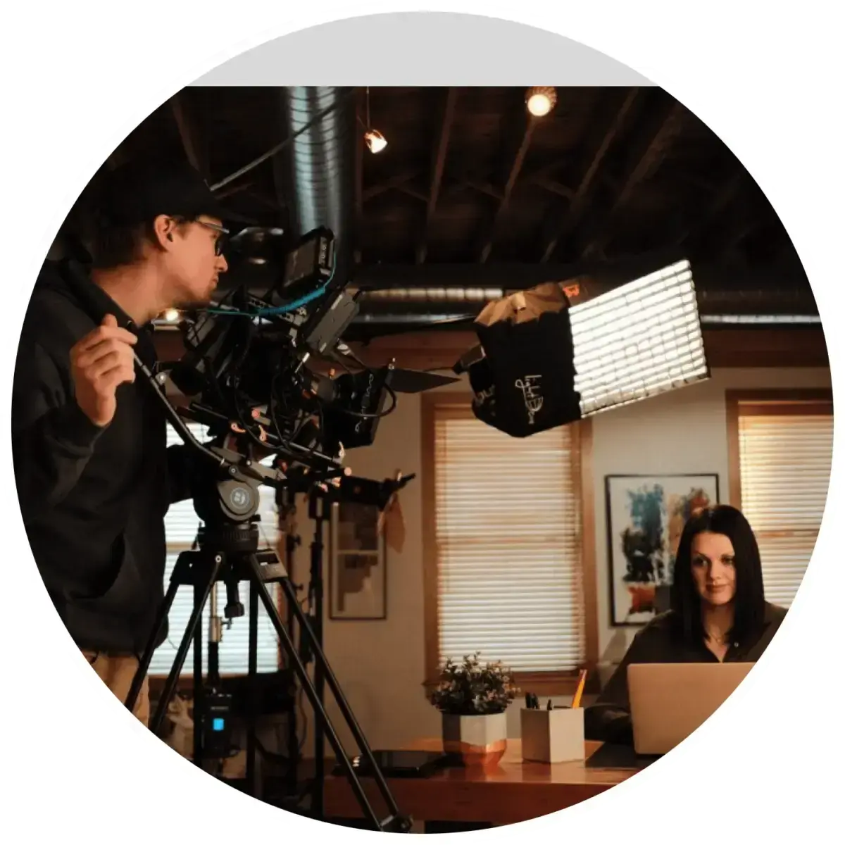video-production-interview-setup-videographer-lighting-woman-at-desk